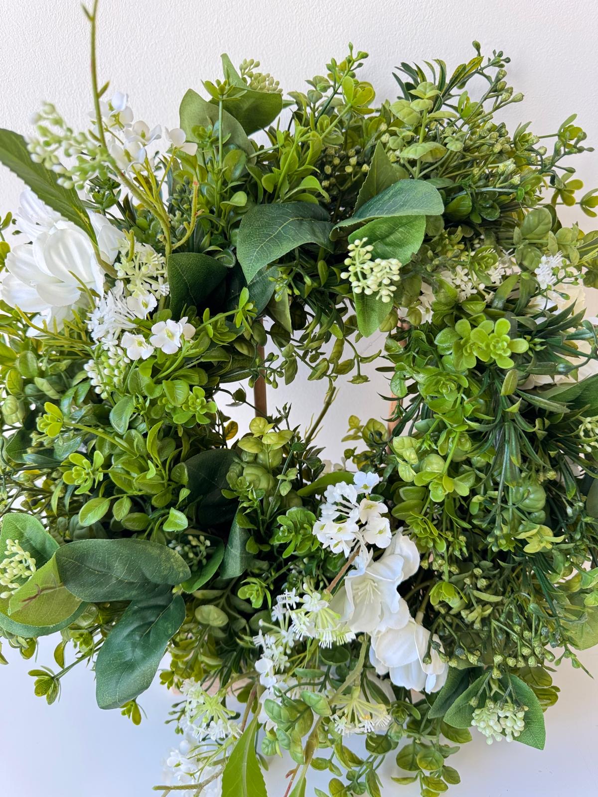 Green spring door decoration with white flowers