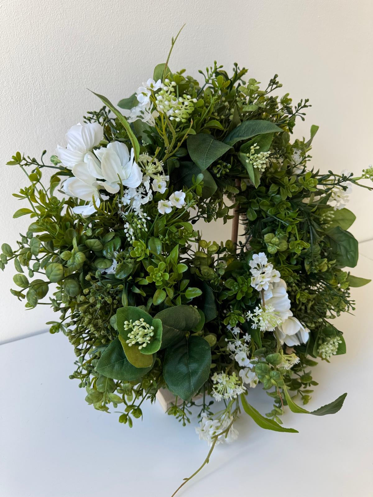 Green spring door decoration with white flowers