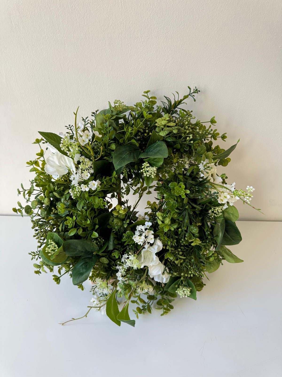 Green spring door decoration with white flowers