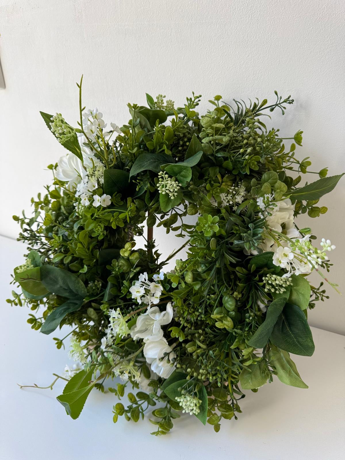 Green spring door decoration with white flowers